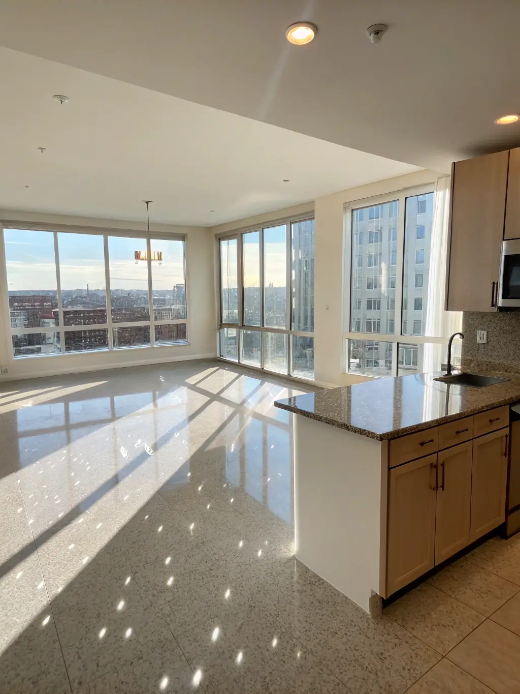 A vacant apartment with sparkling clean kitchen appliances and freshly mopped floors, ready for new tenants after a thorough move-out cleaning service.